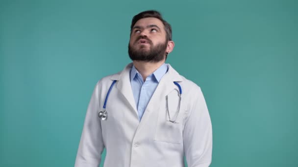 Frustré médecin homme en manteau blanc sur fond de mur bleu. Doc est fatigué, fatigué du travail, il est déçu, impuissant — Video