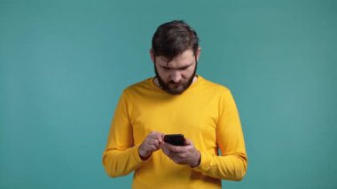 Yakışıklı bir adam cep telefonundan mutlu bir haber alır. Adam şaşkınlık ve sevinçle kendinden geçmiş. Kazandı ve sevindi. Teknoloji, başarı, zafer, mutluluk kavramı.