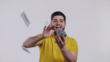 Mutlu yüzlü adam para saçıyor. Sakallı adam Amerikan doları harcıyor. Beyaz stüdyo geçmişinde dolarlar var..