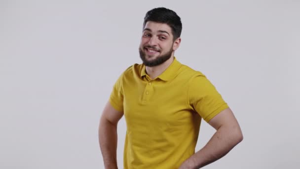 Retrato de hombre alegre caucásico en ropa amarilla. Joven chico guapo sonriendo, señalando a la cámara en el estudio sobre fondo blanco. — Vídeos de Stock