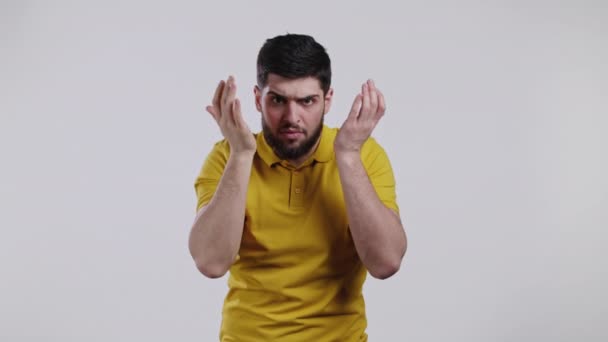 Young man cannot believe his eyes, rubs it and peers more closely at camera on white studio background. Shocked guy with long hairdo just woke up. — Stock Video