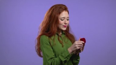 Hayal kırıklığına uğramış kadın, kötü şaka konsepti. Violet 'in arka planında evlilik teklifi olmayan sahte mücevher kutusu tutan güzel bir bayan.. 