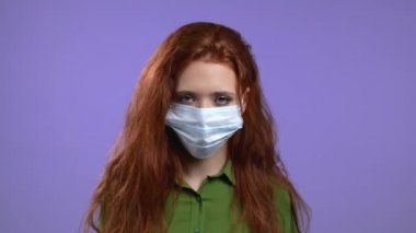 Koruyucu maske takan bir kadın evet işareti gösteriyor başını onaylayarak ve olumsuz bir şekilde sallıyor. Genç kız, vücut dili kavramı. Violet stüdyo geçmişi.