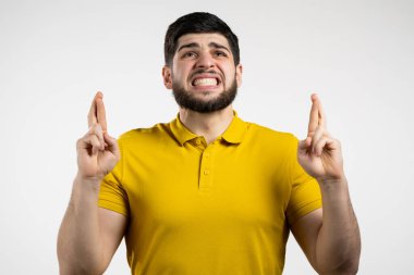 Genç sakallı adam beyaz arka plan için dua ediyor. Adam birine arzularını tatmin etmesi için yalvarıyor..