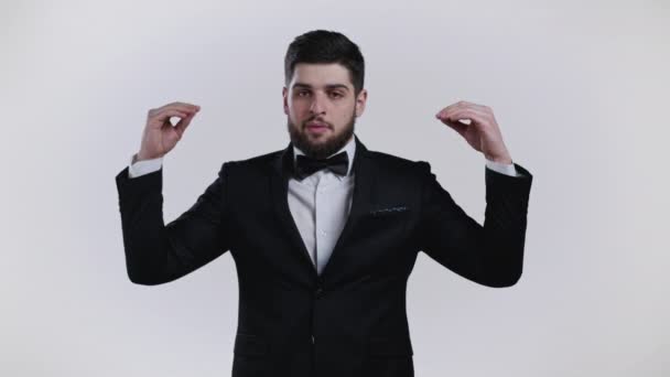 Handsome bored man in tuxedo showing bla-bla-bla gesture with hands isolated on white background. Empty promises, blah concept. Lier — Stock Video