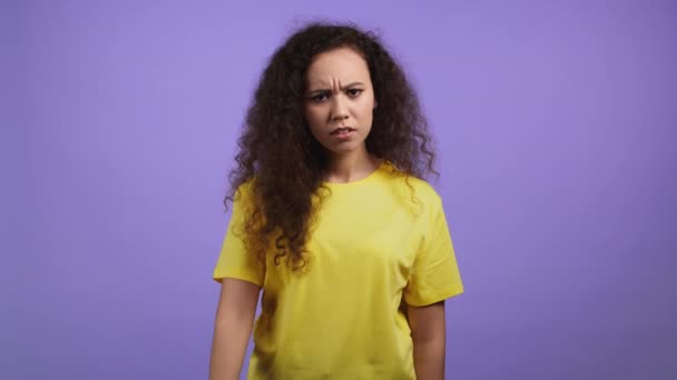 Portrait of serious woman showing rejecting gesture by stop finger sign. Dont play with me. Severe girl in yellow t-shirt isolated on violet background. — Stock Video