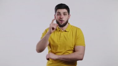 Gülümseyen zeki adam Eureka hareketi yapıyor. Beyaz stüdyo arkaplanını işaret eden bir adamın portresi..