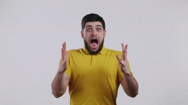 Korkmuş bir adam bir şeyden korkuyor ve beyaz duvar arkasında korku dolu büyük gözlerle kameraya bakıyor. Yüksek sesle bağırıyor. Kötü espri, haber kavramı..