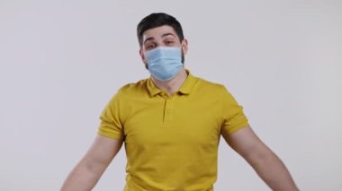 Memnun adam koruyucu maskeyi çıkardı ve salgın hastalığın son bulması için yere attı. Beyaz stüdyo geçmişi.