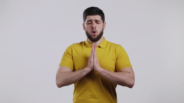Giovane uomo caucasico che prega su sfondo bianco. Guy implorando qualcuno soddisfare i suoi desideri, aiutare con. — Video Stock