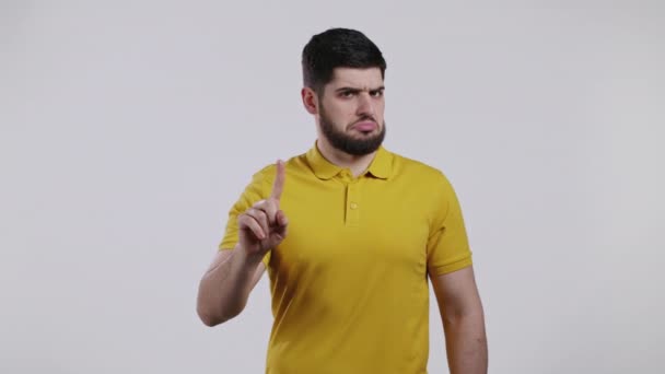 Porträtt av seriös man i gult visar avvisande gest genom stopp finger tecken. Lek inte med mig. Guy isolerad på vit bakgrund. — Stockvideo