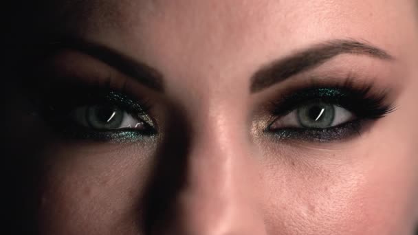 Alleen vrouwelijke ogen. Vrouw met mooie make-up, glinsterende glinsterende oogschaduwen. Meisje knippert met groene ogen, krimpt. Schoonheid, cosmetica, kunst, vrouwelijk concept. concept. — Stockvideo