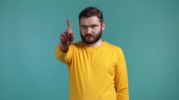 Retrato de un hombre serio en amarillo mostrando gesto de rechazo por señal de stop finger. No juegues conmigo. Tipo aislado sobre fondo azul. — Vídeos de Stock