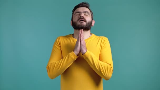 Giovane uomo che prega su sfondo blu. Guy implorando qualcuno soddisfare i suoi desideri, aiutare con. — Video Stock