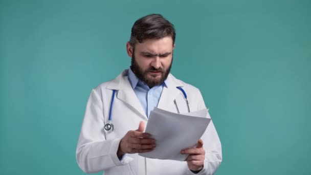 O médico irritado deita fora os papéis. Homem-médico furioso a atirar papel enrugado, a ter um esgotamento nervoso no trabalho, a gritar de raiva, conceito de stress. Azul estúdio fundo — Vídeo de Stock