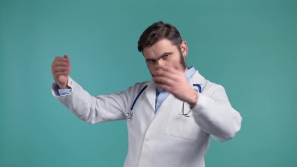 Zelfverzekerde dokter man raakt in de borst, dokter is trots op zichzelf, hoe cool hij is en alles kan doen. Zelfzucht, arrogantie concept. Blauwe studio achtergrond. — Stockvideo