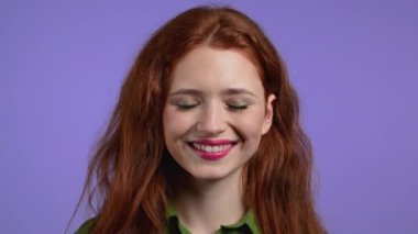 Kızıl saçlı kadın evet işareti gösteriyor, onaylayarak başını sallıyor. Yeşil tişörtlü genç kız, vücut dili konsepti. Violet stüdyo geçmişi.