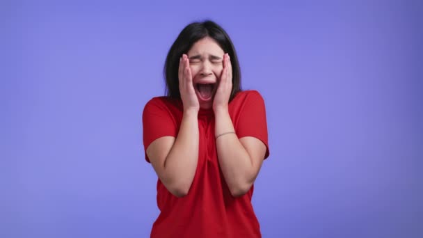 Wanita yang ketakutan dan menjerit terkejut terisolasi dengan latar belakang ungu. Stres dan tertekan gadis asia karena berita buruk. — Stok Video