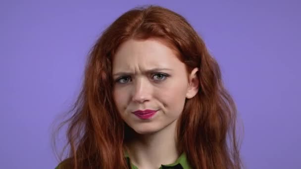 頭のサインなしで赤い髪の不承認と柔軟性のない女性は、鼻の頭をしぶしぶ。拒否,拒否,同意しません,紫のスタジオの背景に女の子の肖像画. — ストック動画