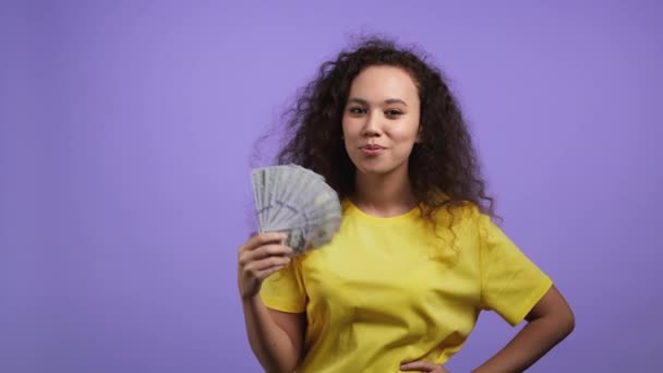 Glimlachende gelukkige vrouw met contant geld - USD valuta dollars bankbiljetten op violette muur. Symbool van jackpot, winst, overwinning, het winnen van de loterij — Stockvideo