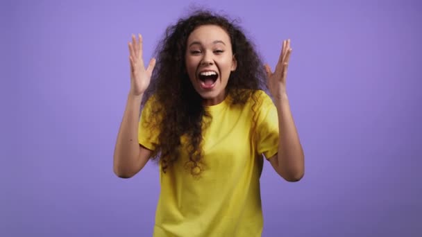 Mixed race woman is very glad, she screaming loud. Concept of sales, profitable offer. Excited happy lady on violet studio background. — Stock Video