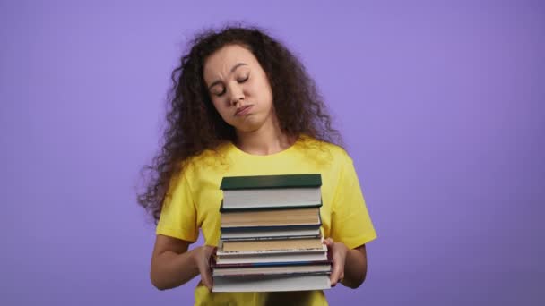 Estudiante europeo está insatisfecho con la cantidad de deberes y libros sobre fondo violeta. Mujer suspira y enrolla los ojos en el desagrado, ella se molesta, desanimado frustrado por los estudios. — Vídeo de stock