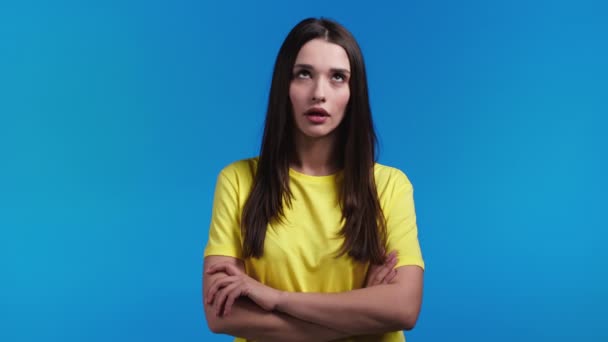 黄色のため息をつくの刺激的な女性は、青い背景に目を圧延。不快で白人女性は、彼女の状況に疲れている、どのようにまだ理解できないと思う. — ストック動画