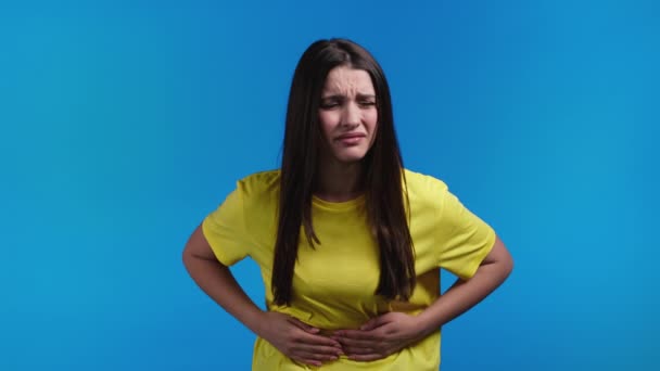 腹痛のために手で腹を絞る女。胃の痛みに苦しんでいる女性。医療,月経期間のけいれんや腸の鼓腸の概念の問題 — ストック動画