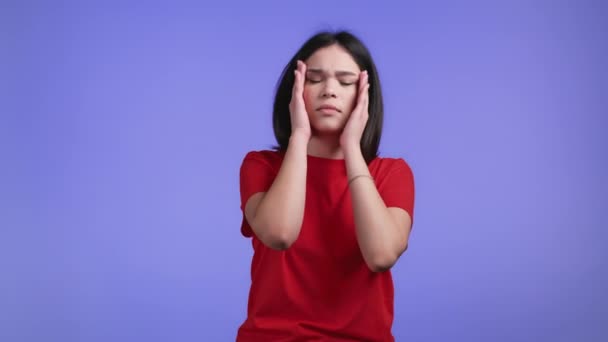 Bored woman portrait, her head is spinning around on violet background. Pretty girl is tired of situation. Headache, migraine concept. — Stock Video