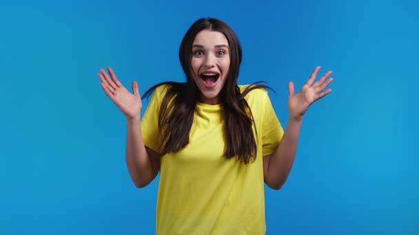Spaanse vrouw is erg blij, ze schreeuwt WOW luid. Concept van verkoop, winstgevend aanbod. Opgewonden gelukkig dame op blauwe studio achtergrond. — Stockvideo