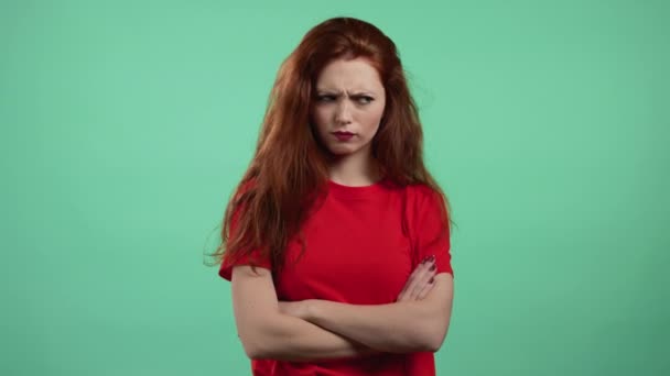 Femme offensée gardant les bras croisés, se sentant en colère contre quelqu'un sur fond de studio vert. Expressions faciales, émotions et sentiments humains. Langage corporel. — Video