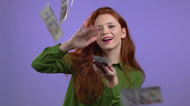 Lucky woman with happy face scatters money. Lady is overspend USD currency. Girl is flush with dollars on violet studio background. — Stock Video