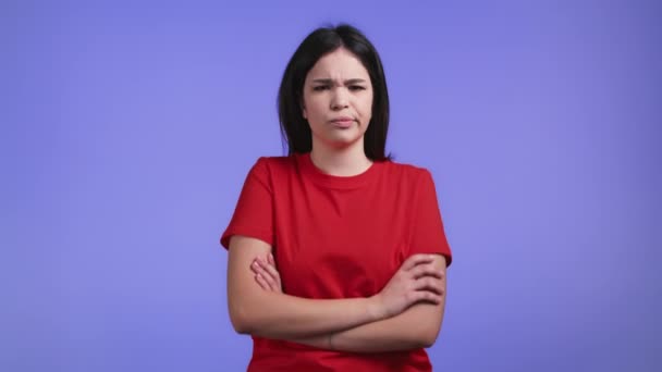 Mujer ofendida manteniendo los brazos cruzados, sintiéndose enojada con alguien en el fondo del estudio violeta. Expresiones faciales humanas, emociones y sentimientos. Lenguaje corporal. — Vídeos de Stock