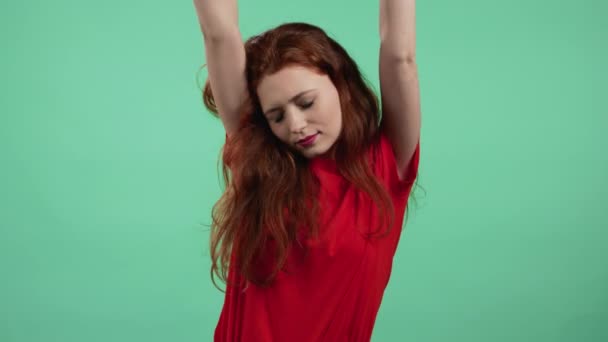 Tired sleepy woman yawns. Girl stretches hands up. Very boring, uninteresting. Green studio background. — Stock Video
