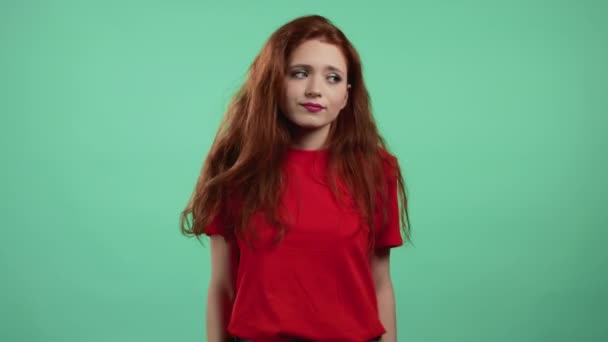 Indifferente donna incerta fa un gesto di non so, non può aiutare nulla. Concetto di domanda difficile. Ragazza con i capelli rossi su sfondo studio verde. — Video Stock