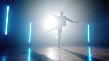 Sahne ışıkları altında çağdaş dansçı kadın silueti. Profesyonel balerin dumanlı sahnede, mavi lambalar, tek başına performans..