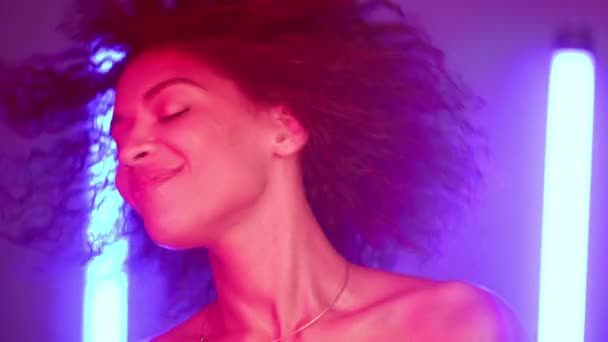 Cool disco dans unik afro kvinna under neon glödande ljus. Flerfärgad bild av dam som rör sig till musik rytm. Millennial hipster generation. Parternas uppfattning. — Stockvideo