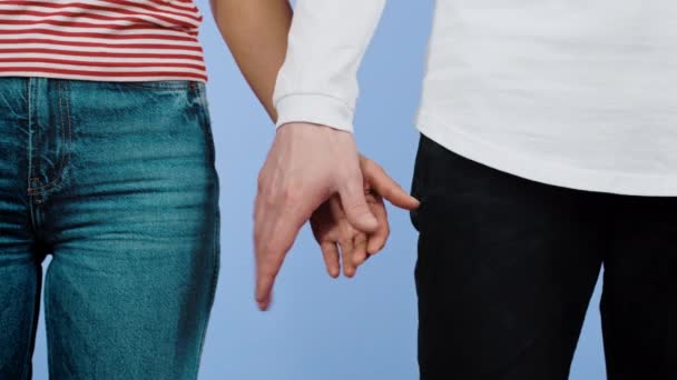 Руки африканской женщины и белого мужчины держатся вместе, как символ межрасовой дружбы. Изолирован на фоне фиолетовой студии. Любовь против расизма. Межрасовая пара. — стоковое видео