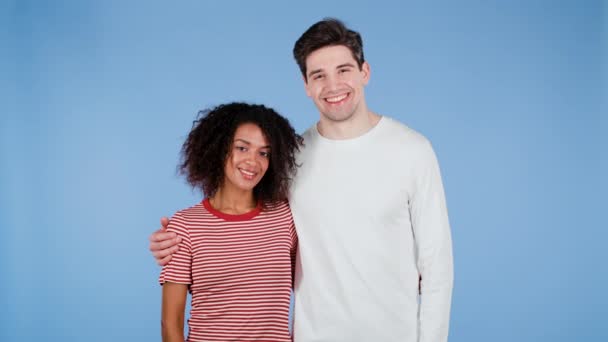 Retrato de jovem casal em fundo estúdio azul. Mulher afro-americana e homem branco. raça inter-racial amor conceito — Vídeo de Stock