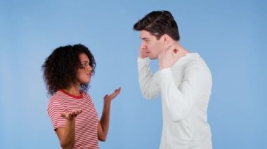 Irklar arası genç çift mavi arka planda duygusal olarak tartışıyor. Çatışma kavramı, ilişkilerde sorunlar. Afrikalı Amerikalı kadın ve beyaz adam.