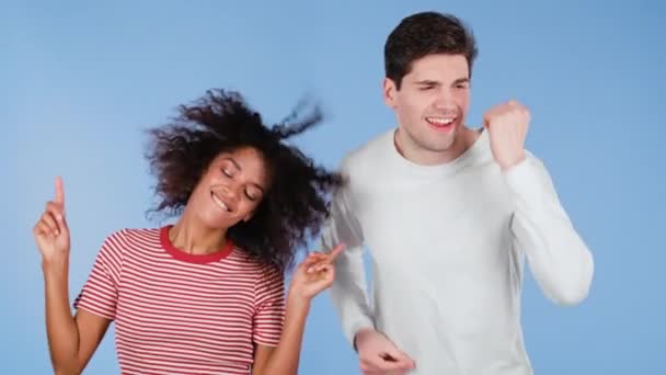 Молодая африканская американка и белый мужчина танцуют изолированно на синем фоне. Вечеринка, счастье, музыка, концепция межрасовой пары. — стоковое видео
