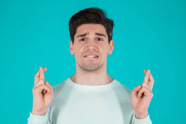 Young man praying over blue background. Guy in white wear begging someone satisfy his desires, help with. — Stock Photo, Image