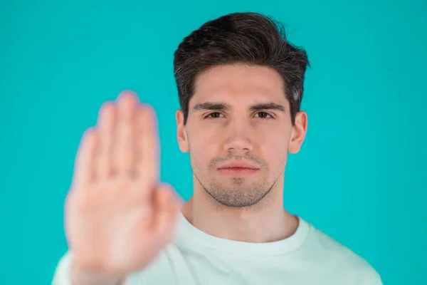 Egy komoly férfi portréja, amint elutasító gesztust mutat a tenyér kézjegyével. Guy elszigetelt kék háttér. — Stock Fotó
