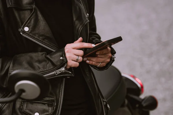 Motosikletli kadın portresi cep telefonu kullanıyor, akıllı telefon kullanıyor. Genç bir motorcu seyir subayı kullanıyor.. — Stok fotoğraf