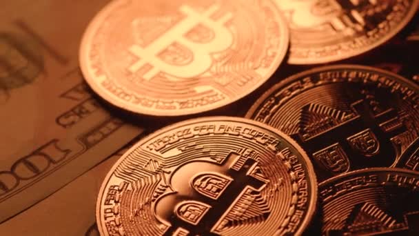 Κοντινό πλάνο των bitcoins περιστρέφεται σε χαρτονομίσματα των 100 δολαρίων. Cyberspace, cryptocurrency, επένδυση. Τεχνολογία Blockchain, εξόρυξη. — Αρχείο Βίντεο