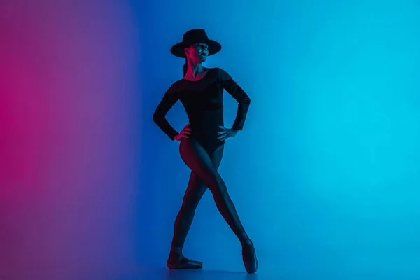 多色グラデーションピンクブルーの背景にポーズをとる帽子の現代的なバレエダンサーの女性。プロフェッショナルバレリーナでセクシー衣装の女性のファタール,ソロパフォーマンス. — ストック写真
