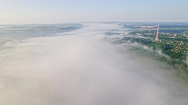 Sabahın erken saatlerinde geniş nehir üzerinde hava aracı görüntüsü. Suyun üzerindeki büyülü sis. Şehir sağ kıyıda.