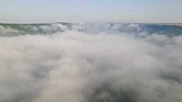 Aerial drone view. Camera flying above clouds in the sky. River surface covered with morning mist. Calmness background, relaxation, beauty of earth, nature concept — Stockvideo