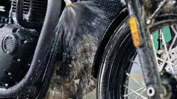 Motocicleta muito suja no momento da lavagem depois da condução fora de estrada. Radiador de lavagem com água de motocicleta preta clássica. Estilo Caferacers, câmara lenta. Manutenção de veículos a motor — Vídeo de Stock