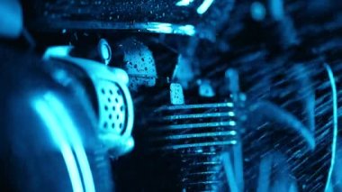 RGB renk ışığı altında off-road sürüşünden sonra yıkanan motosiklet. Geceleri klasik siyah motosiklet suyuyla yıkama motoru. Caferacers tarzı. Motorlu araçların bakımı